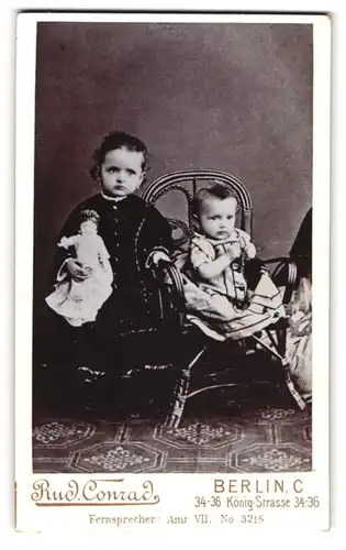 Fotografie Rud. Conrad, Berlin, König-Str. 34-36, Portrait zwei kleine Kinder mit Puppe in der Hand