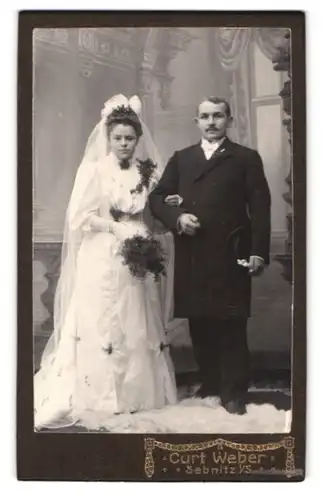 Fotografie Curt Weber, Sebnitz i. S., Portrait sächsisches Ehepaar im Hochzeitskleid und Anzug posieren für Fotografen