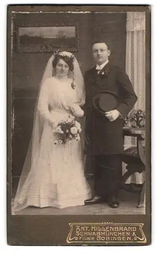 Fotografie Ant. Hillenbrand, Schwabmünchen, Portrait Eheleute im Hochzeitskleid und Anzug mit Chapeau Claque