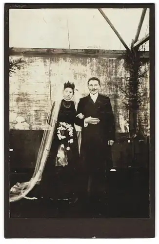 Fotografie unbekannter Fotograf und Ort, Portrait Ehepaar im schwarzen Brautkleid und Anzug mit Moustache