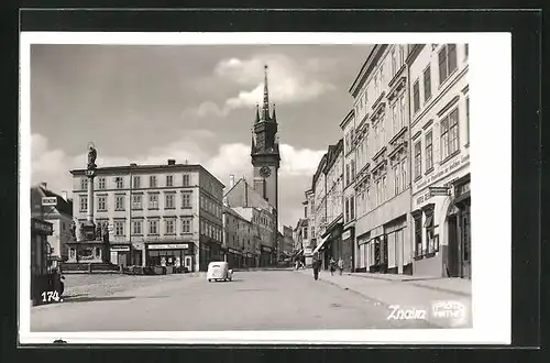 AK Znaim, Strassenpartie mit Hotel, Geschäften und Denkmal