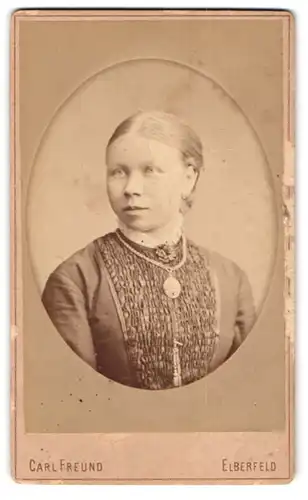 Fotografie Carl Freund, Elberfeld, Hofauerstrasse 80, Portrait junge Dame mit Kragenbrosche und Amulett