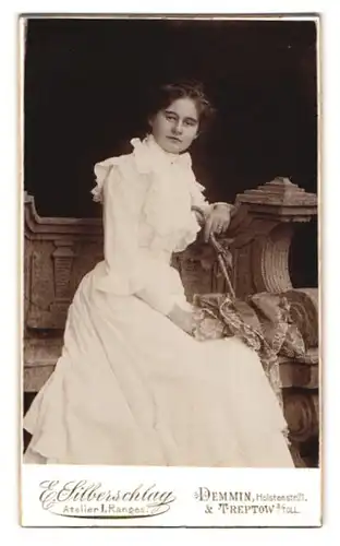 Fotografie E. Silberschlag, Demmin, Holstenstr. 21, Portrait hübsche junge Frau im weissen Kleid auf einer Steinbank