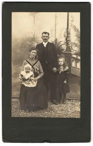 Fotografie unbekannter Fotograf und Ort, Portrait Mutter und Vater mit zwei Kindern in einer Studiokulisse, Mutterglück