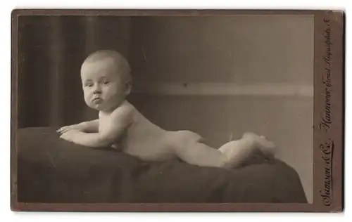 Fotografie Samson & Co., Hannover, Ernst Augustplatz 5, Portrait nackiges Kleinkind liegt bäuchlings auf Decke