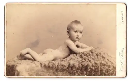 Fotografie Carl Thies, Hannover, Höltystrasse 13, Portrait nackiges Kleinkind liegt bäuchlings auf Fell