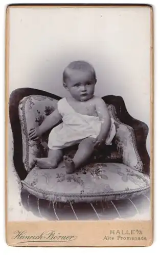 Fotografie Heinrich Börner, Halle / Saale, Alte Promenade, Kleinkind in weissem Laibchen auf gepolstertem Sessel