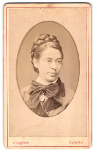 Fotografie C. Höpfner, Halle / Saale, Alter Markt 1, Dame mit zum Kranz geflochtenen Haaren trägt ein Medallion