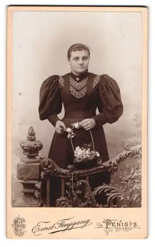 Fotografie Ernst Freygang, Penig i. / S., Dame in dunklem Kleid mit Puffärmeln posiert mit Korb in Naturkulisse