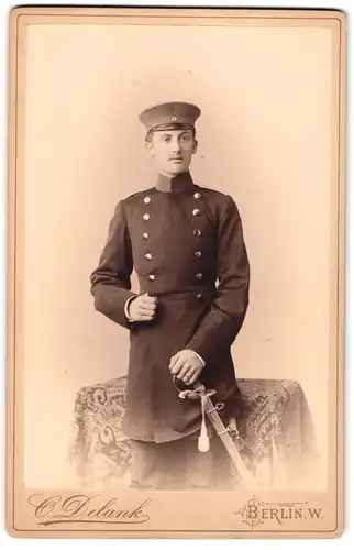 Fotografie C. Delank, Berlin, Friedrichstr. 185, Portrait junger Soldat in Uniform mit Säbel