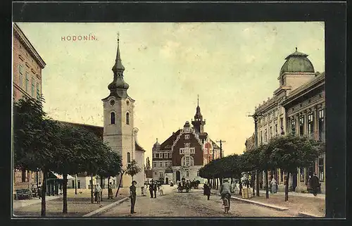 AK Göding / Hodonin, Strassenpartie mit Passanten, Kostel