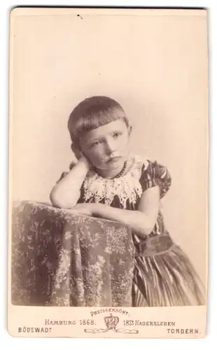 Fotografie Jacob A. Bödewadt, Tondern, Portrait kleines Mädchen im Kleid mit aufgestütztem Kopf