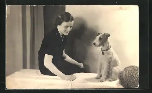 Foto-AK Mädchen mit Terrier auf Bett