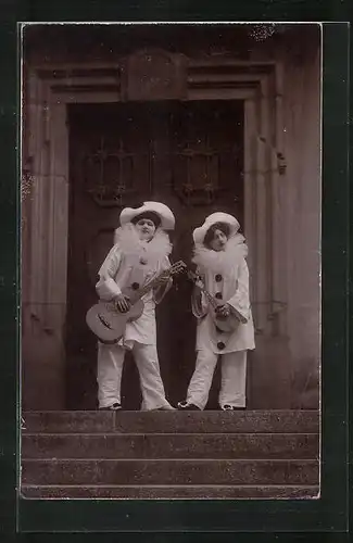 AK Harlekine musizieren mit ihren Gitarren vor einem Haus