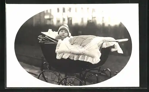 Foto-AK Säugling blickt verdutzt aus Kinderwagen