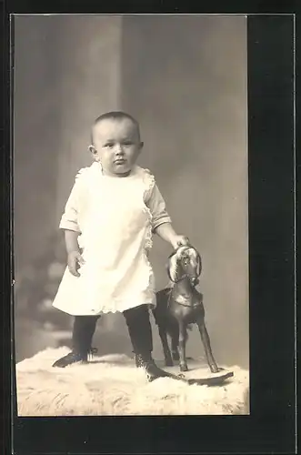 Foto-AK Kleinkind auf Fell mit Schaukelpferd