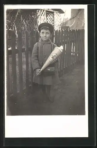 Foto-AK Kind mit Schultüte am Zaun, Schulanfang