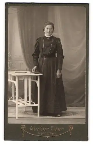 Fotografie Atelier Eder, Kempten, Frau mittleren Alters im hochgeschlossenem Kleid mit Buch in der Hand