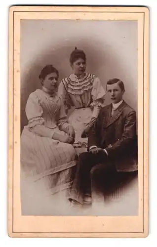 Fotografie unbekannter Fotograf und Ort, Portrait junger Herr mit zwei Damen in hübscher Kleidung