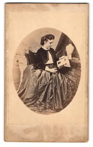Fotografie unbekannter Fotograf und Ort, Prinzessin Maria Anna von Dessau-Anhalt betrachtet ein Fotoalbum