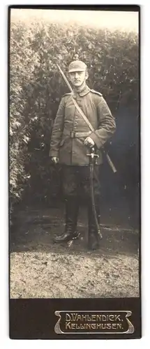 Fotografie D. Vahlendiek, Kellinghusen, Bergstrasse 10, Soldat in Feldgrau mit Pickelhaube im Tarnbezug und Säbel