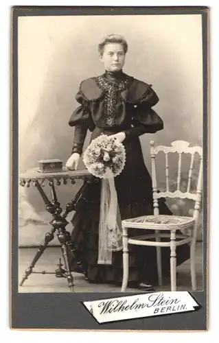 Fotografie Wilhelm Stein, Berlin, Chaussee-Strasse 66, Fräulein im Puffärmelkleid mit Blumenstrauss zur Kommunion