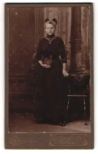 Fotografie W. Dalchow, Egeln, Junge Frau im schwarzen Kleid und Schleife im Haar mit Bibel zur Kommunion