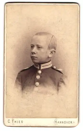 Fotografie C. Thies, Hannover, Höltystr. 13, Portrait Knabe als Soldat in Gardeuniform mit kahlem Kopf