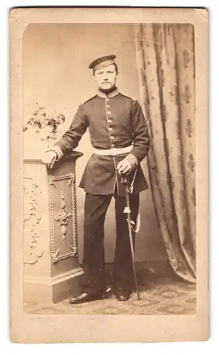 Fotografie unbekannter Fotograf und Ort, Portrait Soldat in Uniform mit Säbel und Krätzchen
