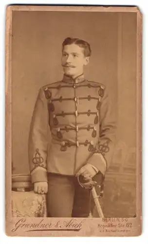 Fotografie Grundner & Abich, Berlin, Köpenicker Str. 62, Portrait Uffz. in Husaren Uniform mit Säbel