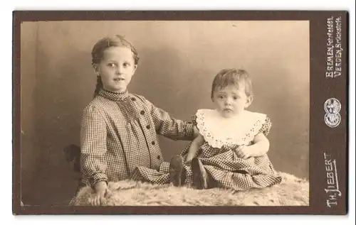 Fotografie Th. Liebert, Bremen, Fehrfeld 61, Portrait hübsches Mädchen im karierten Kleid mit Kleinkind