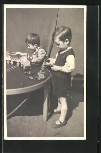 Foto-AK Zwei kleine Jungen spielen mit Holzeisenbahn