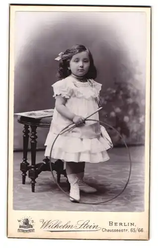 Fotografie Wilhelm Stein, Berlin, Chausseestr. 65-66, Portrait kleines Mädchen im Kleid mit Reifen