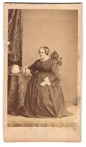 Fotografie H. Holz, München, Wurzer-Str. 14, Portrait Dame mit hoher Stirn im Biedermeierkleid und Vogel auf dem Tisch