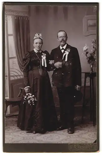 Fotografie Joh. Verra, Rosenheim, Innstr. 1, Portrait älteres Brautpaar im schwarzen Kleid und Anzug mit Haarschmuck