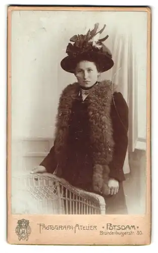 Fotografie Photg. Atelier, Potsdam, Brandenburgerstr. 30, Portrait junge Dame im Kleid mit Pelzstola und breitem Hut