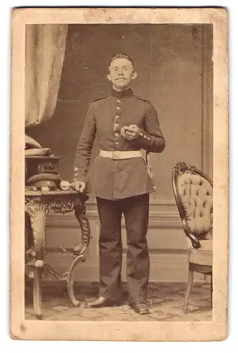 Fotografie unbekannter Fotograf und Ort, Portrait junger Soldat in Uniform posiert im Atelier am Sekretär
