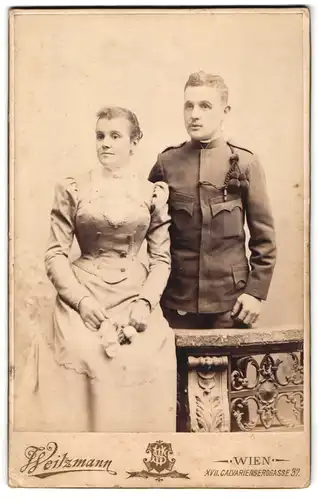 Fotografie Weitzmann, Wien, Calvarienberggasse 37, Portrait junger Soldat in Uniform mit Schützenschnur, nebst Frau