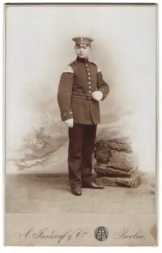 Fotografie A. Jandorf & Co., Berlin, N. Brunnenstr. 19-21, Portrait junger Militär Musiker in Uniform mit Schwalbennest