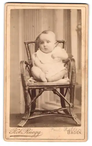 Fotografie Rob. Rüegg, Baden, Baby sitzt auf einem Stuhl