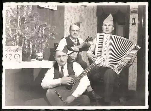Fotografie Musiker-Trio mit Akkordeon, Gitarre & Okulele nebst Weihnachtsbaum