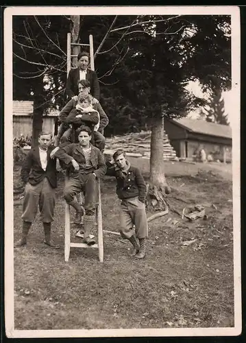 Fotografie Burschen posieren auf und neben einer Leiter