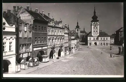 Fotografie unbekannter Fotograf, Ansicht Louny, Marktplatz mit Ladengeschäften & Rathaus