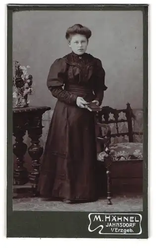 Fotografie M. Hähnel, Jahnsdorf /Erzgeb., Junge Frau in dunklem Kleid mit Buch in der Hand