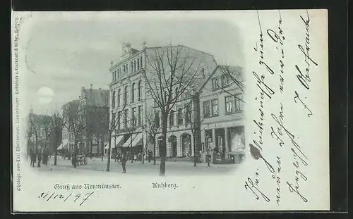 Mondschein-AK Neumünster, Strasse Kuhberg mit Geschäften