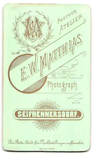 Fotografie E.W. Matthias, Seifhennersdorf, Mädchen mit enger Frisur und Geschwisterchen in Tracht