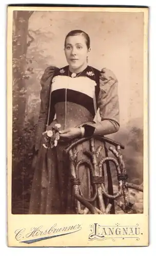 Fotografie C. Hirsbrunner, Langau, Bürgerliche Dame im enggeschnürtem Kleid mit Blume