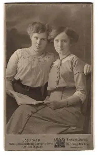 Fotografie Jos. Raab, Braunschweig, Bohlweg 40 a, Portrait zwei modisch gekleidete Damen mit Zeitung