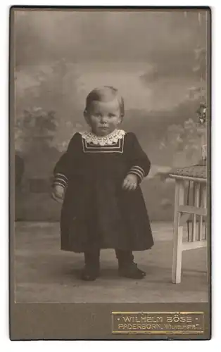 Fotografie Wilh. Böse, Paderborn, Wilhelmstrasse 11, Portrait kleines Kind im Kleid mit Spitzenkragen