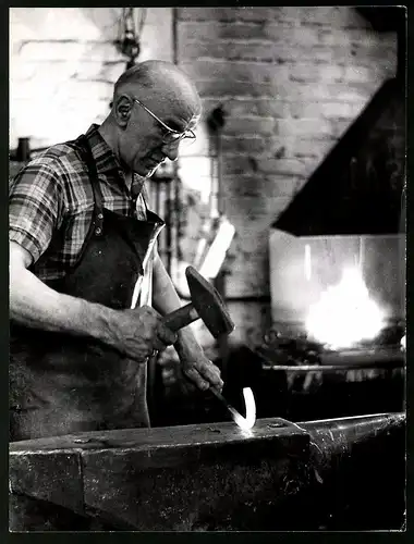 Fotografie Hans Lachmann, Düsseldorf-Urdenbach, Schmied bearbeitet glühendes Werkstück mit Hammer & Amboss
